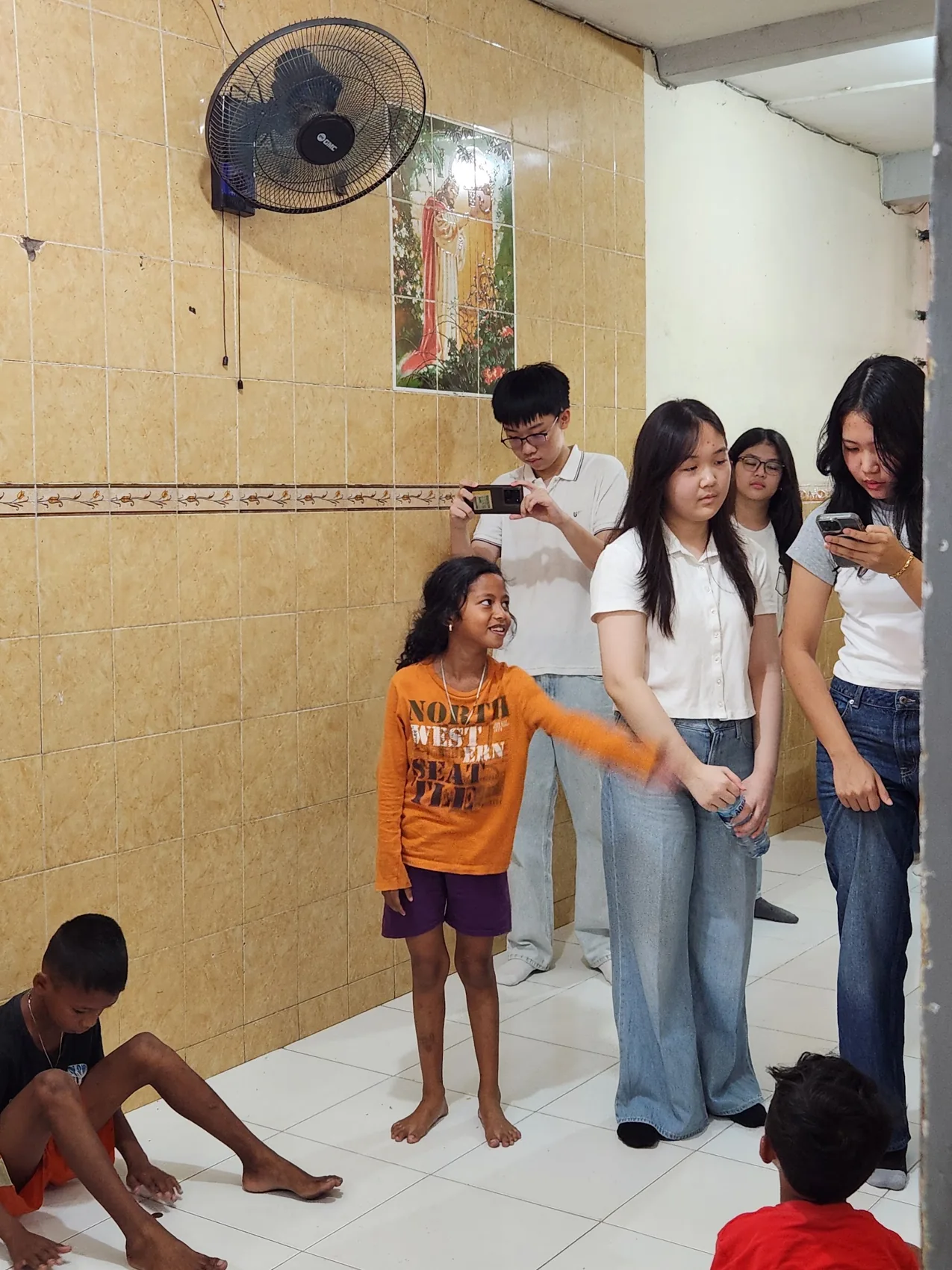 Volunteers leading a standing group activity indoors.