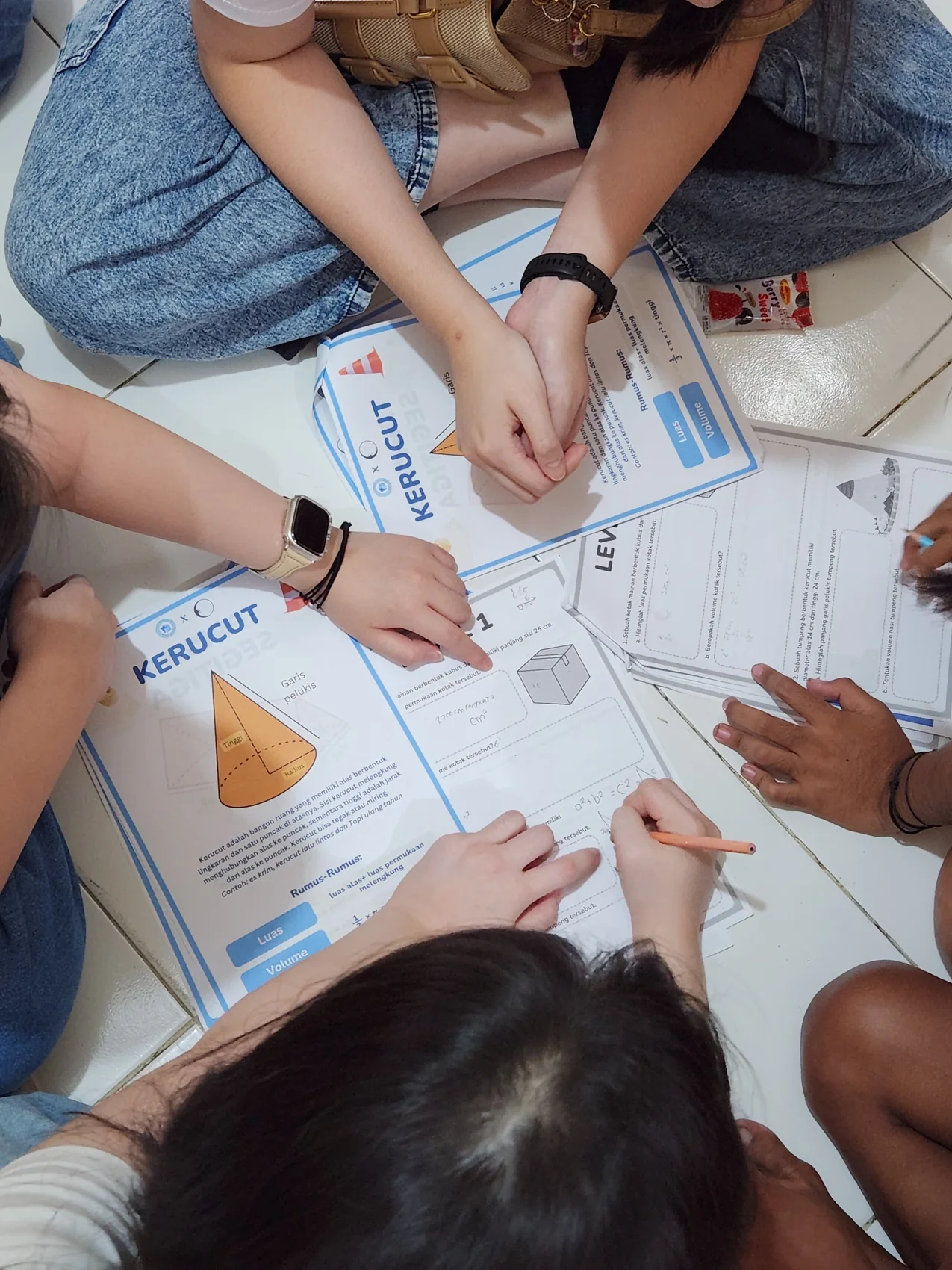 Children and volunteers working together on illustrated worksheets.