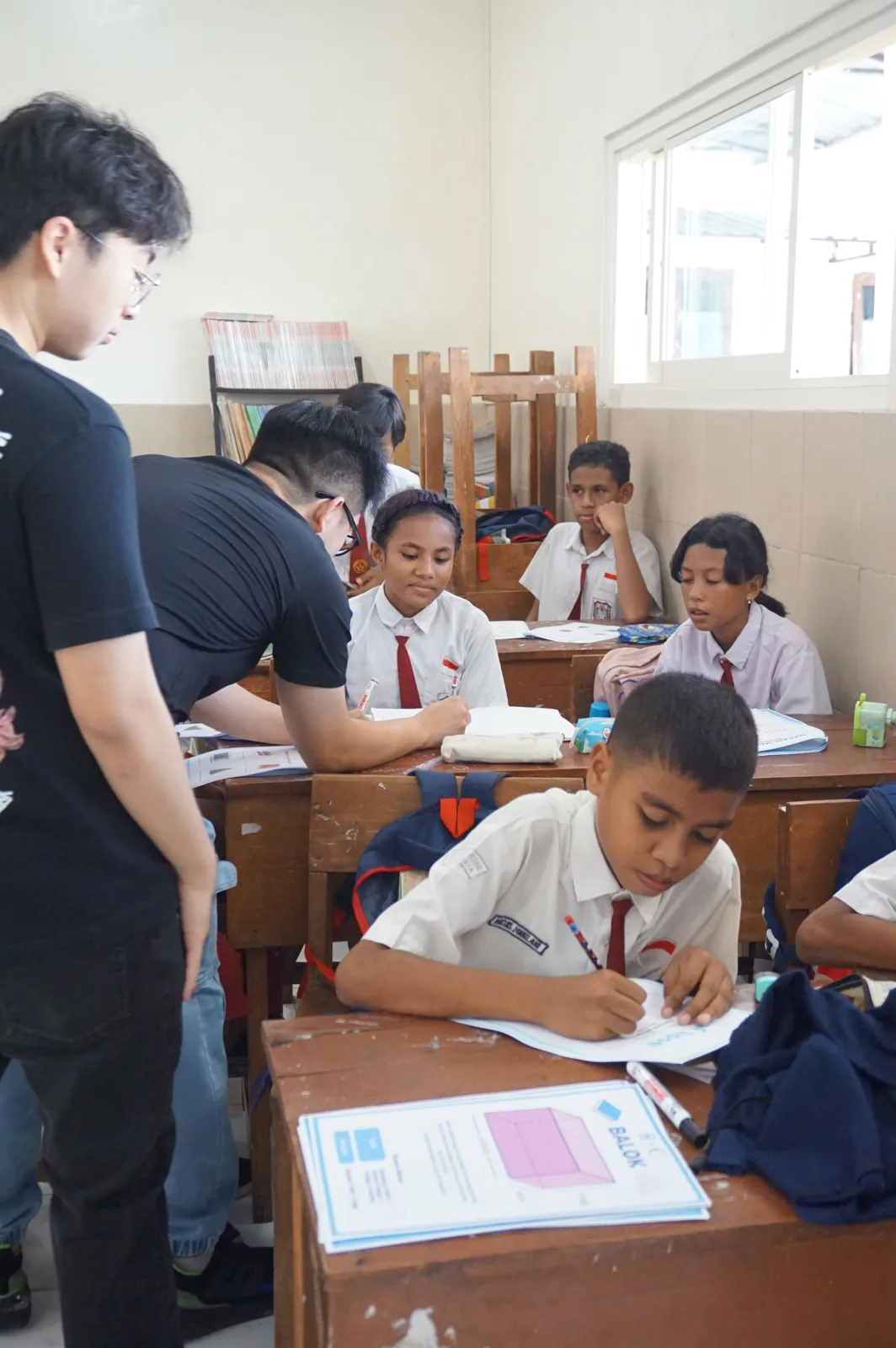 Volunteers guiding students through a classroom activity