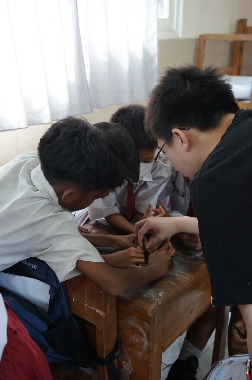 Children and a volunteer working on a practical experiment