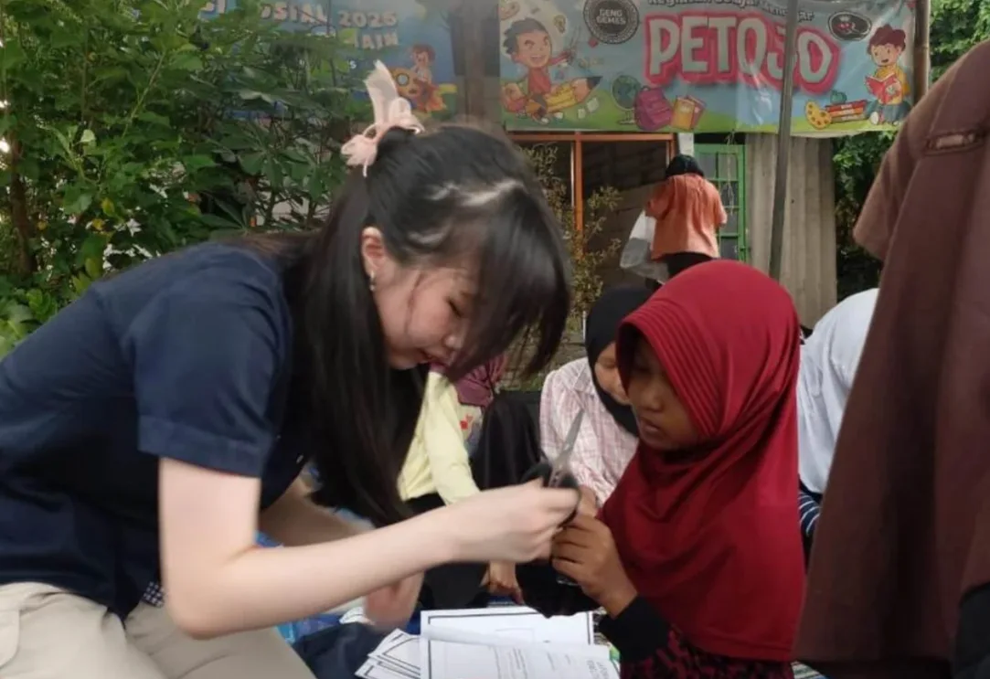 A volunteer helping a child with a learning activity