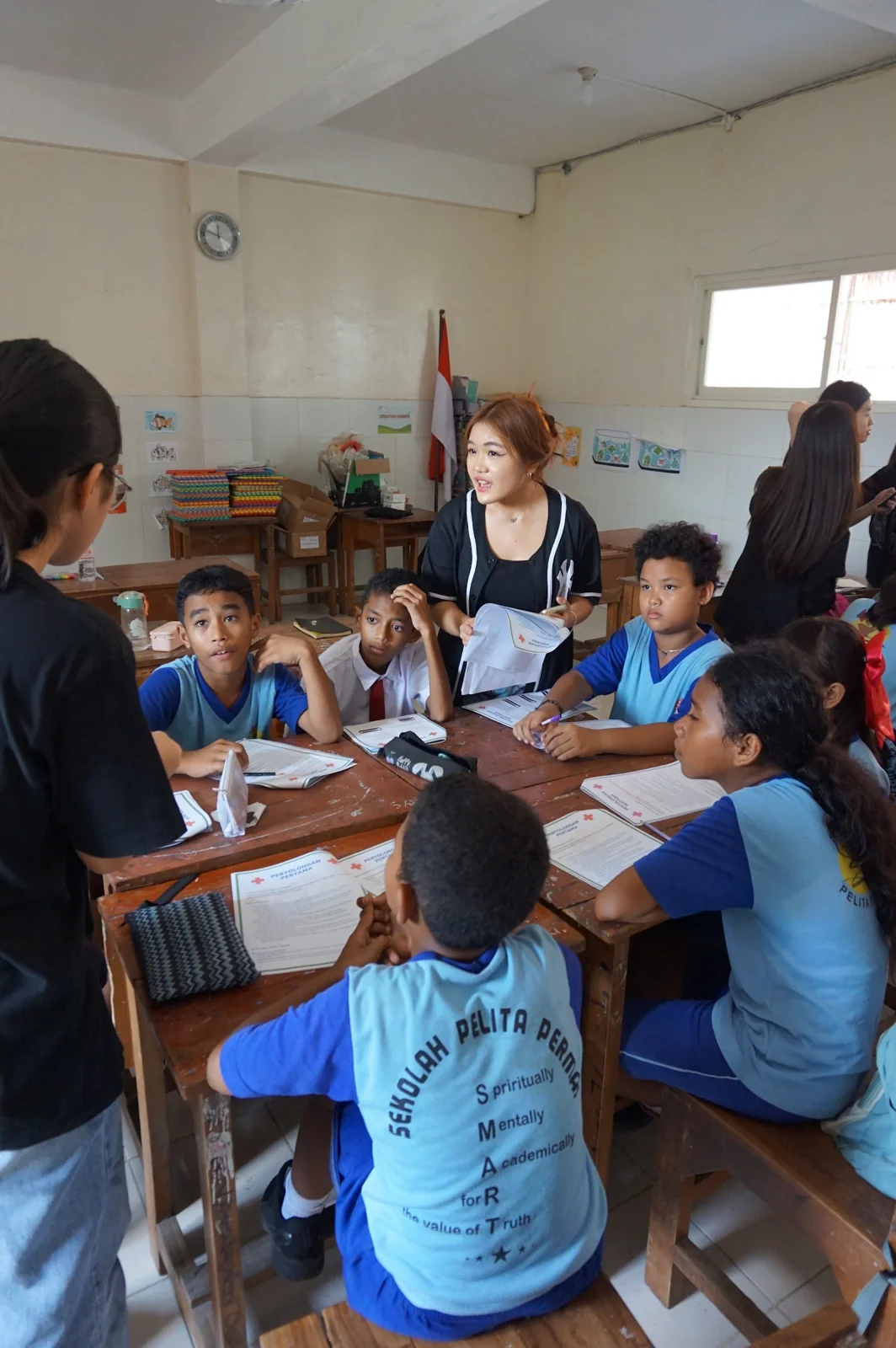 Students discussing a workbook with EclipseLearns volunteers